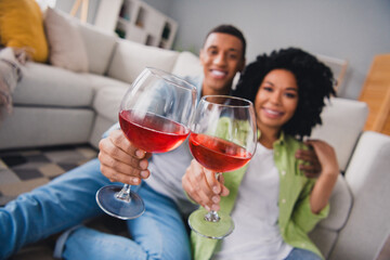 Photo of nice young man girl sit floor celebrate anniversary date drink wine modern interior indoors cozy daylight apartment living room