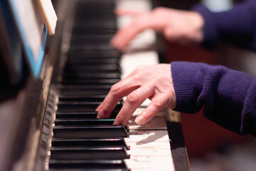 Obraz premium fingers close up playing piano music, used old dusty authentic instrument 