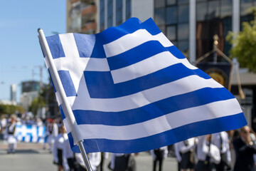Greek flag fluttering in front of student parade