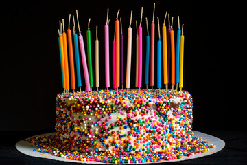 Celebration birthday cake with colorful sprinkles and colorful birthday candles - 781451205