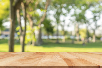 Wooden table top on blur nature bokeh green park background. Empty Wooden tabletop used for...