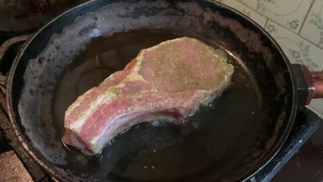Fried and braised pork steak in a frying pan