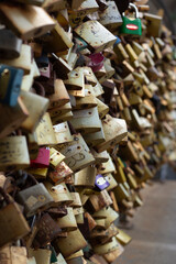 Street photo. Many golden metal locks on fence of bridge. Symbol of eternal love. Concept of wedding day, love, relationships, family, valentine's day, friendship, secrets, privacy. Traditional fun. 