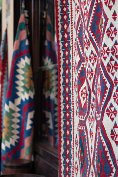 Vertical photo. Carpet shop in Tbilisi. Variety of gorgeous oriental persian rugs in traditional Middle Eastern rug store. Handmade red carpets at street bazaar in southern country. Flea market. Sale