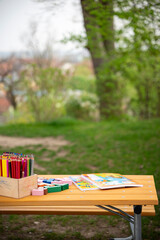 Kindertisch im Freien. Malen im Garten. Bilderbücher und Buntstifte