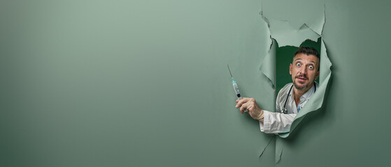 A surprised man in a lab coat looks through a large tear in green paper, holding a syringe as if caught off-guard