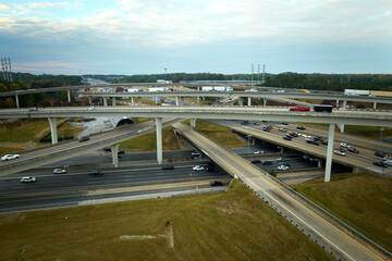 American freeway intersection with fast driving cars and trucks. View from above of USA transportation infrastructure
