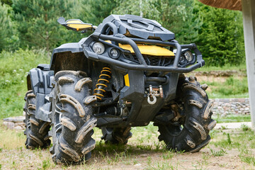 Large four-wheeler ATV vehicle is parked on green grass. Quad bike for offroad