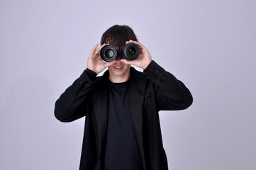 fotografo segurando lentes fotogr&aacute;ficas como bin&oacute;culo 