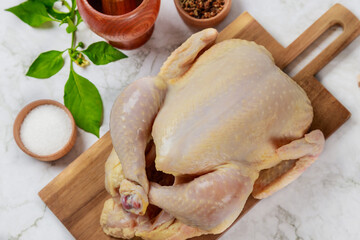 A raw chicken is prepared for cooking with spices.