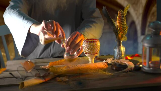 The alchemist's table and his hands in close-up  in a medieval chemical laboratory workshop