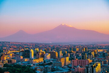 Breathtaking aerial view of the Yerevan cityscape with the silhouette of Mount Ararat on sunset sky