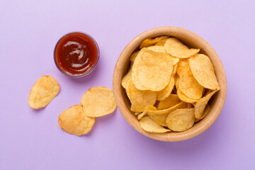 Appetizing potato chips on color background, top view