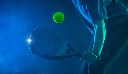 Padel tennis player with racket on tournament. Girl athlete with paddle racket on court with neon colors. Sport concept. Download a high quality photo for design of a sports app or tour events. - 781507627