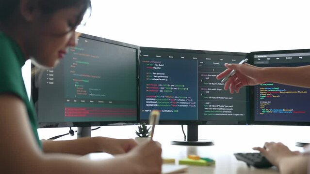Back end software developer engineer for computer programming working together on debugging writing computing code, solving complex algorithms display on monitor in office. Burgeoning