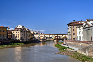 Fototapeta na wymiar Bridge, tenement houses and historic buildings over the Arno river in the city of Florence
