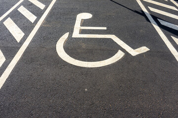 Disabled parking sign painted on ground. Symbol indicating reserved parking space for individuals...
