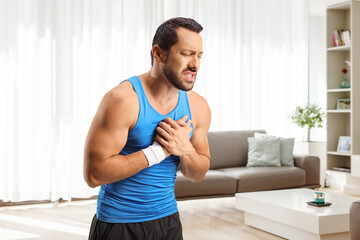 Man in a living room holding his chest in pain at home