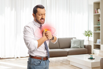 Businessman in a living room holding his chest in pain at home
