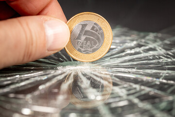 Brazil money, 1 Brazilian real coin reflecting in broken glass, Financial concept, Brazilian currency, Rate drop, analysis and forecast for Brazil, close up