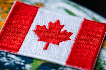 Canada flag, beautiful patch and maple leaf symbol against the background of the world, Close up