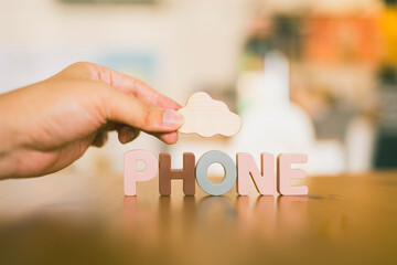 A hand holding a symbol of a cloud with text PHONE, which indicates the cloud computing system.