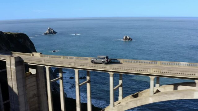 Iconic Journey: Drone Shot of Car Crossing Bixby Bridge in Big Sur, California