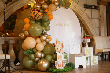 birthday photo zone with large green, beige and gold balloons