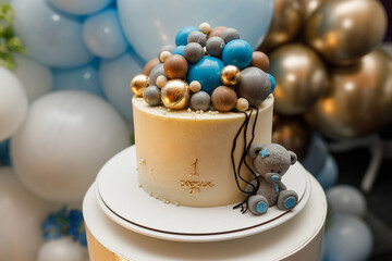 birthday cake with blue chocolate balls and teddy bear figurine