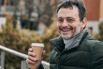 middle aged man drinking coffee outside