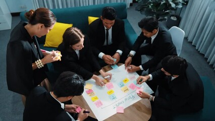 Top view of business people making scrum task board to manage workflow in workplace. Diverse marketing team drawing a line and use colorful stick notes to work on kanban. Creative office. Directorate.