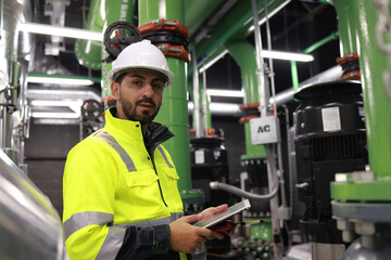 Portrait of an energy engineer Working to inspect the cooling system of the air conditioner in the basement of the building.