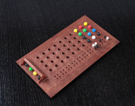 Mastermind game in progress isolated on a black background, United Kingdom