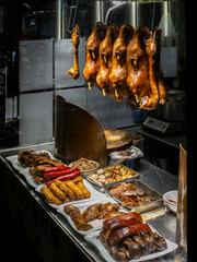 Roasted goose, heads and other type of meat hanging in a restaurant window in Hong Kong