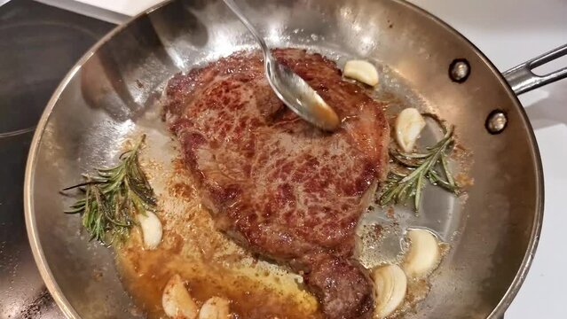 Beef steak with garlic, rosemary and butter fried in a frying pan