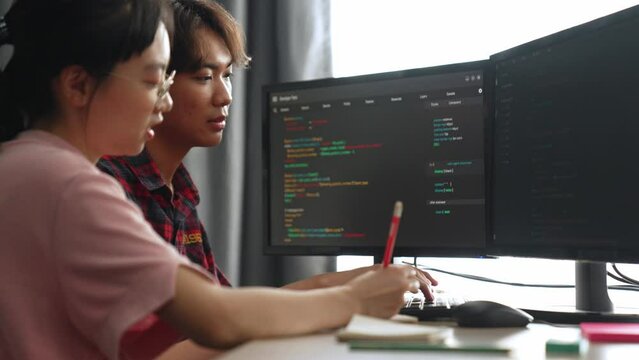 Slow motion back end software developer engineer for computer programming working together on debugging writing computing code, solving complex algorithms display on monitor in office. Burgeoning