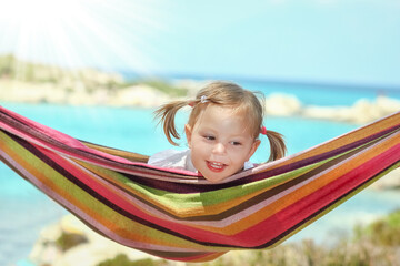 happy child by the sea on hammock in greece background - 781532252