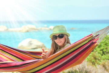 happy child by the sea on hammock in greece background
