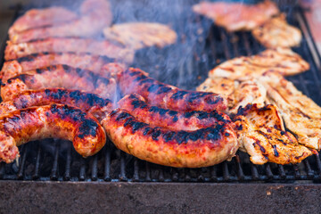 Pork meat and sausages grilled on a charcoal barbeque. Top view of tasty barbecue, food concept,...