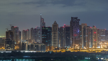 Fototapeta na wymiar Jumeirah lake towers skyscrapers and golf course night to day timelapse, Dubai, United Arab Emirates
