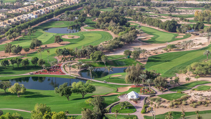 Fototapeta na wymiar Aerial view to villas and houses with Golf course with green lawn and lakes timelapse
