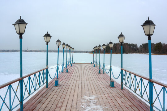 A beautiful pier with lanterns. View of Valdai Lake from the pier on a cloudy spring day.
