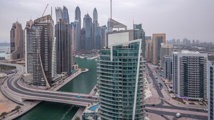 Aerial view of Dubai Marina residential and office skyscrapers with waterfront day to night...