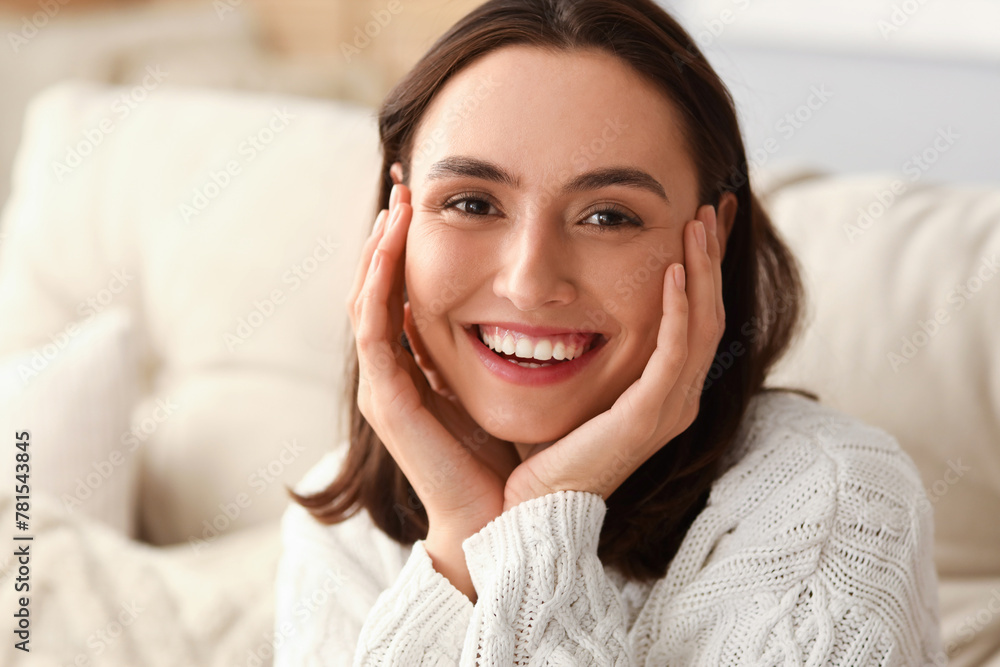 Sticker Young woman in warm sweater at home, closeup