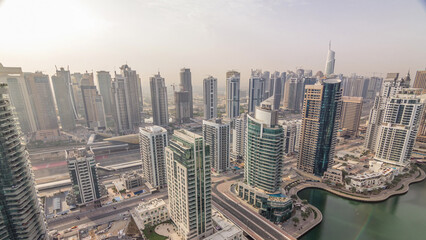 Fototapeta na wymiar Aerial top view of Dubai Marina morning timelapse. Modern towers and traffic on the road