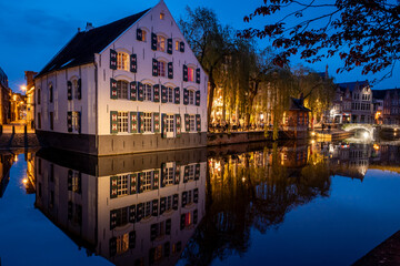 Lier city in Belgium at night. warm lights reflect evening water people eat and drink in street old houses historic building Buyldragershuisje and de fortuin. nightlife on Feix timmermansplein square