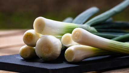Close up of details of fresh green onions (scallion) on a cutting board isolated.