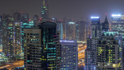 Aerial top view of Dubai Marina night timelapse. Modern towers and traffic on the road