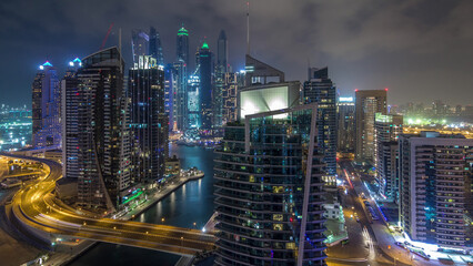 Aerial view of Dubai Marina residential and office skyscrapers with waterfront night timelapse...