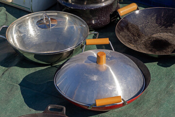Professional steel cooking wok dishes sold on market outdoors